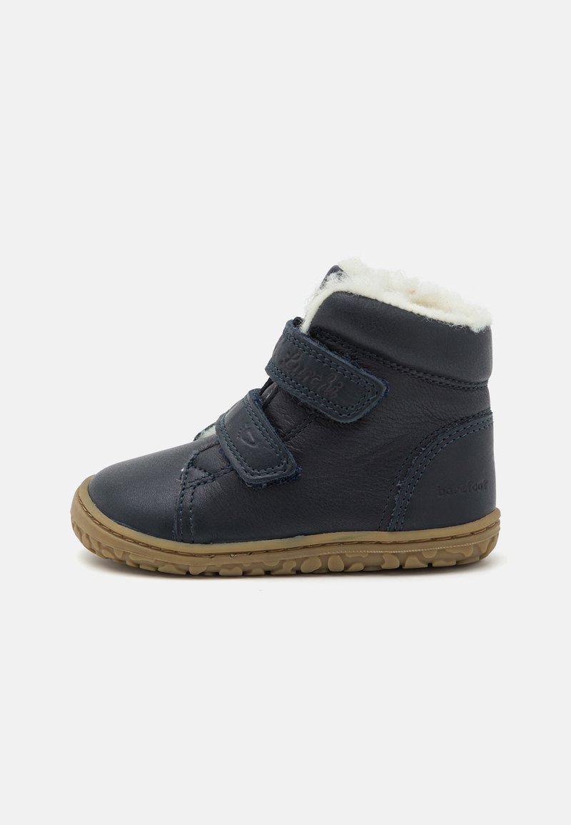 Bottine bleu marine pour tout-petit avec deux bandes Velcro, semelle en caoutchouc marron clair et doublure en polaire blanche à l’intérieur.