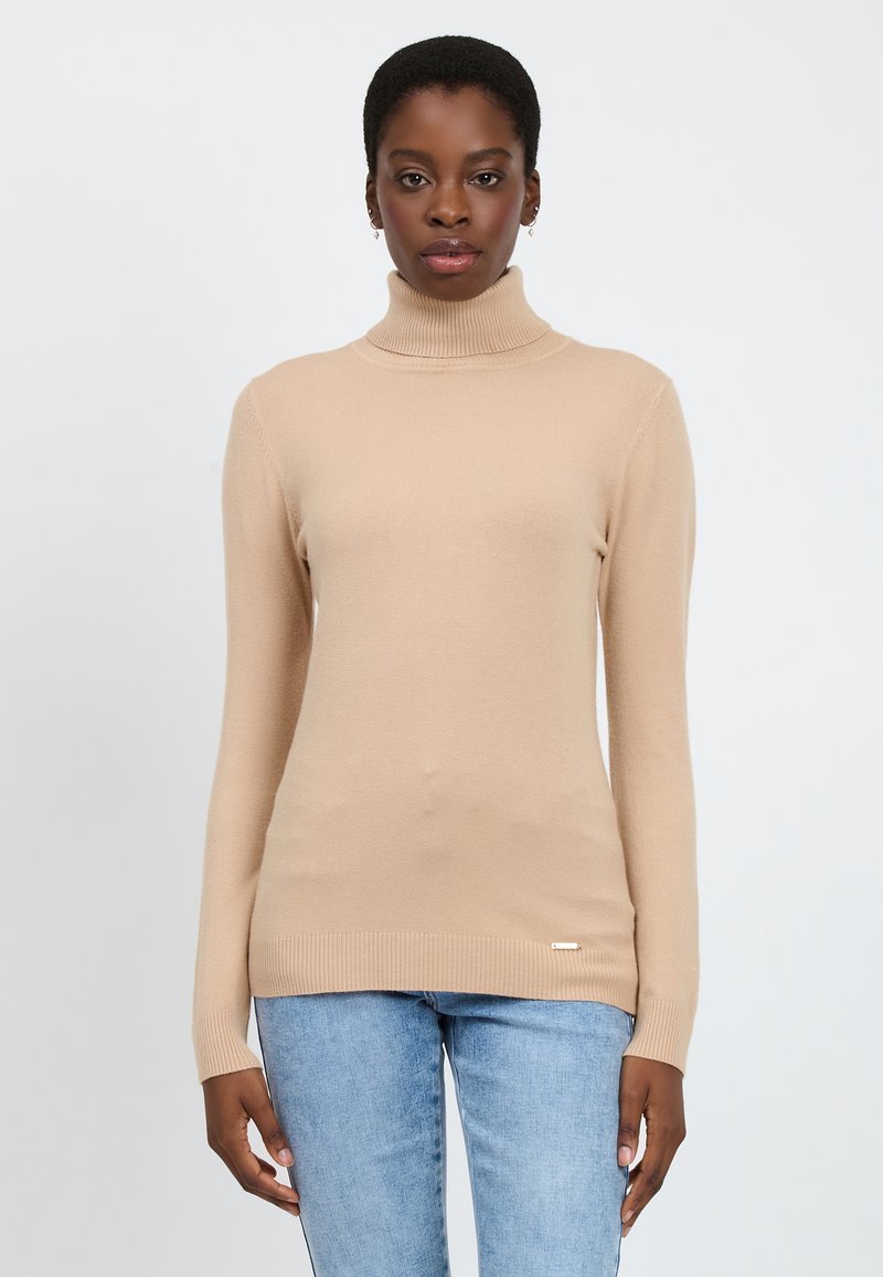 Maglione beige a collo alto con maniche lunghe, polsini e orlo a costine, realizzato in un tessuto morbido e liscio. Nessun motivo o dettaglio particolare.