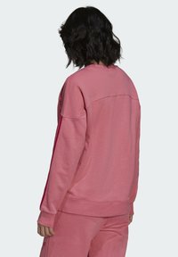 Rosa sweatshirt med avslappnad passform, ribbade muddar och rund halsringning. Mjuk bomullsblandad tyg med slät textur.