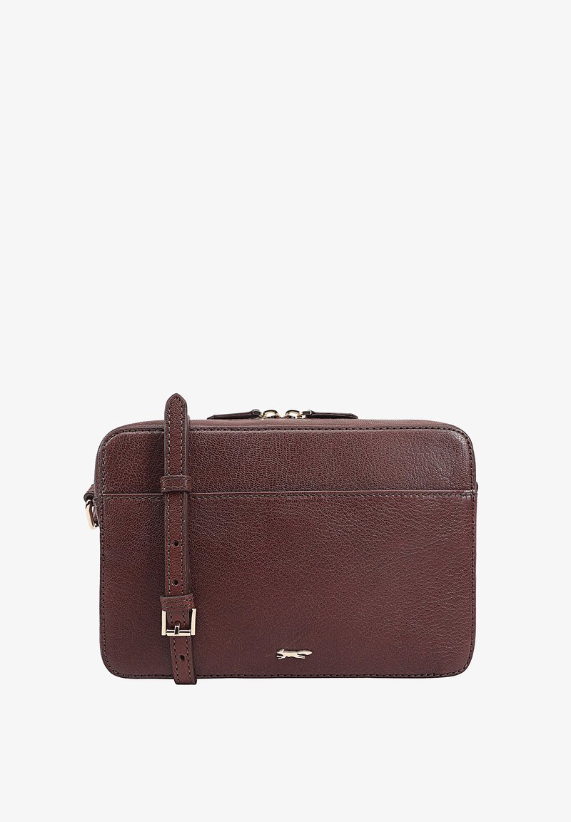 Sac en cuir marron avec une finition texturée, fermeture éclair et bandoulière réglable. Présente un détail logo discret sur le bas à l'avant.