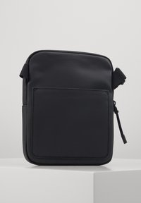 Borsa a tracolla nera con superficie testurizzata e resistente, dotata di una tasca frontale e di una tracolla regolabile per una maggiore versatilità.