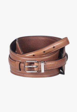 Ceinture en cuir brun roulée avec surpiqûres blanches, boucle rectangulaire argentée, et plusieurs trous de réglage sur fond blanc.