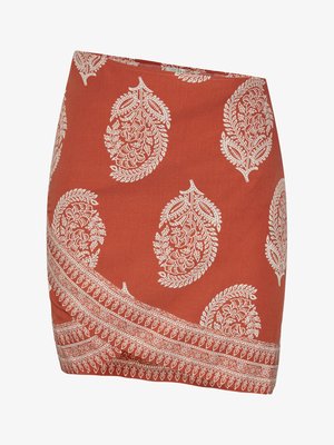 Rūsvas krēklis ar baltajiem paisleju un ziedu rakstiem. Iezīmējas ar diagonālu apakšmalu un sarežģītu apmali gar apakšējo malu.