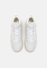 Höga sneakers i vitt läder med perforerade detaljer, rund tån, vadderad krage och kontrasterande beige sula. Utrustad med vita skosnören.