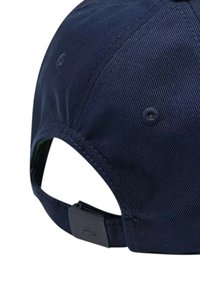 Cappellino blu navy con visiera curva, realizzato in tessuto testurizzato. Presenta una fascia regolabile e un dettaglio con logo sul retro.