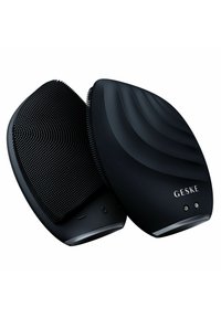Brosse à cheveux noire avec un design ergonomique, dotée de poils en silicone striés et d'un boîtier en plastique lisse et courbé embossé avec "GESKE."