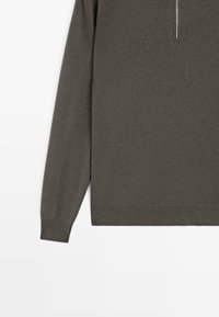 Maglione a maniche lunghe grigio scuro in maglia con zip parziale sul davanti e polsini e orlo a costine su sfondo bianco.