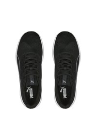 Zapatillas deportivas negras con parte superior de malla, punta redonda, cordones planos y suela blanca. Presentan un logo de Puma en la lengüeta y en el lateral.