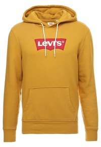 Felpa gialla con cappuccio, dotata di tasca frontale e caratterizzata da un logo rosso Levi's sul petto. Tessuto morbido e cordini completano il design.