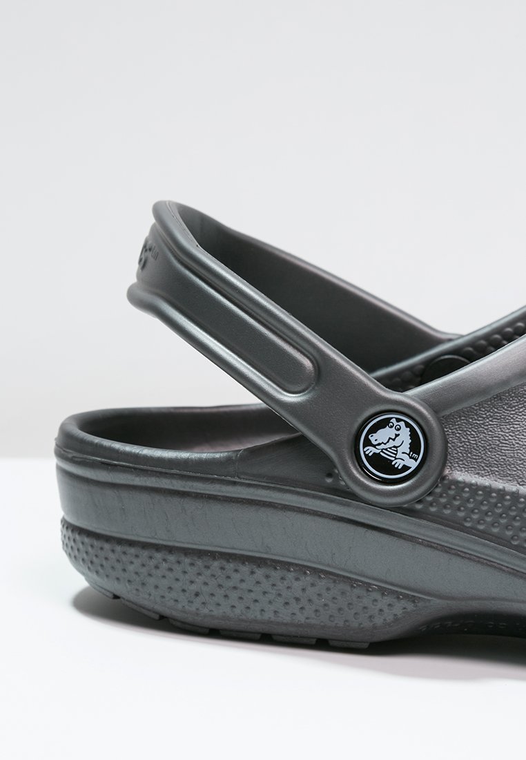 Grijze schoeisel met een gestructureerde zool, verstelbare band en ronde logodetail. Gemaakt van duurzaam, lichtgewicht materiaal, ontworpen voor comfort.