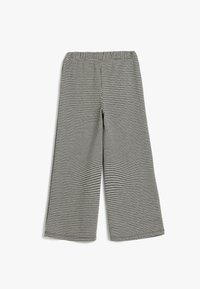 Schwarz-weiße Hahnentritt gemusterte weit geschnittene Hose mit elastischem Bund, gefertigt aus einem strukturierten Stoff.