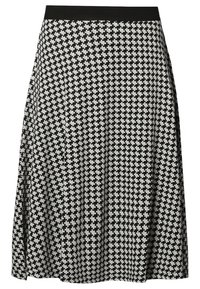 Jupe noire et blanche longueur genou avec un petit motif de signe plus et une ceinture noire unie.