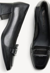 Des mocassins à talons blocs en cuir noir présentent un design élégant, une pointe carrée et un accent métallique sur la lanière. Finition texturée et doublure lisse.