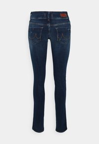 Jeans de ganga azul escuro com um corte slim, apresentando cinco bolsos e costuras angulares nos bolsos traseiros. Design limpo com um desgaste mínimo.