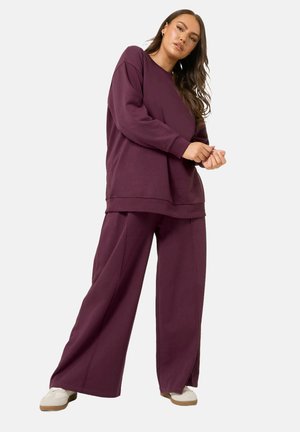 Lila übergroßer Sweatshirt und passende weit geschnittene Hose aus weichem Stoff, mit lockerer Passform und minimalen Nähten.