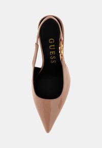 Sandal con tacco in pelle verniciata beige, con punta affusolata, dettaglio in oro evidente e una soletta nera con il nome del marchio.