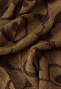 Ύφασμα με υφή σε καφέ βάση και σκούρο καφέ αφηρημένο λουλουδάτο μοτίβο, με μαλακές πτυχώσεις και υφαντό φινίρισμα.