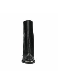 Botte noire en cuir jusqu'au milieu du mollet avec un petit talon et un détail métallique sur la pointe, vue de face sur fond blanc.