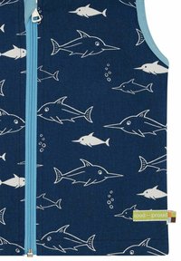 Marine Weste mit einem weißen Fischmuster und einem hellblauen Reißverschluss. Der Stoff hat eine glatte Textur und ist am Saum mit einem Markenlabel versehen.