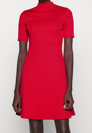 Rotes, geripptes Kleid mit hohem Ausschnitt und kurzen Ärmeln. Eng anliegender Oberkörper, der in einen leicht ausgestellten Rock übergeht. Glatte Textur, keine sichtbaren Muster.