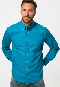 Camicia azzurra in cotone, con colletto classico e maniche lunghe. Tessuto liscio con orlo dritto e bottoni a vista.
