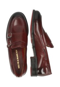 Bordowe skórzane buty z podwójnym zapięciem na klamry, niskim obcasem i szczegółowym przeszyciem; zaokrąglony przód z gładką fakturą.