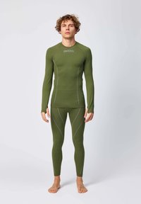 Langsleeve, getailleerde groene thermoshirt en bijpassende leggings met grijze stikseldetails. Ontworpen voor comfort en warmte. Zachte textuur.
