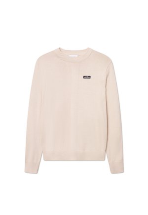Maglione beige a girocollo realizzato in tessuto morbido. Presenta maniche e orlo a coste, con un piccolo logo nero cucito sul petto. Vestibilità classica.