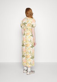 Virágmintás maxi ruha, kiemelt derékkal, rövid ujjakkal, pasztell színekben, könnyű, texturált anyagból, zöld és rózsaszín levelekkel.