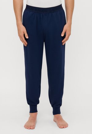 Navy blue jogger-housut, joissa on elastinen vyötärö ja joissa on "Polo Ralph Lauren" -logo kaarteltu. Kapeaverkkoinen malli, jossa on käänteet, valmistettu pehmeästä kankaasta.