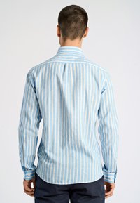 Camicia a maniche lunghe a righe blu chiaro e crema con colletto button-down e polsini a contrasto, caratterizzata da una texture morbida e un orlo curvo.