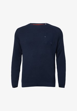 Donkerblauwe gebreide trui met lange mouwen, geribbelde textuur, accentzakje op de linkerse borst en een rode detail aan de binnenkant van de hals.