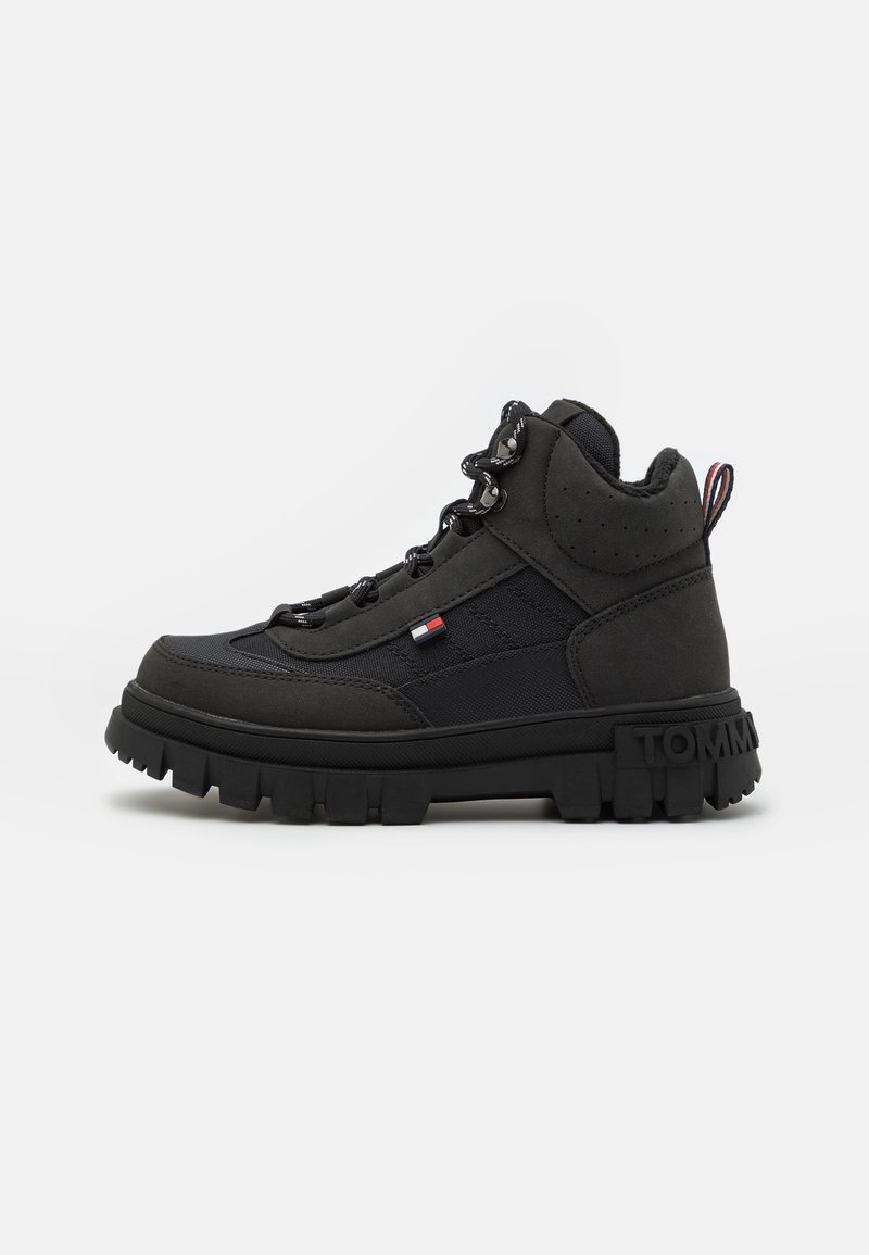 Czarne wysokie buty z chropowatego materiału, wyposażone w solidną podeszwę, wiązany design oraz mały detal logo na boku.