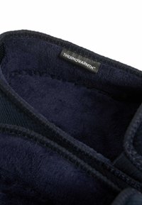 Stivale termico blu navy con morbido rivestimento in pile, cuciture visibili e un'etichetta con la dicitura "THERMOWARMTH™" vicino al bordo.