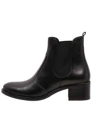Bottine en cuir noir avec un bout arrondi, des panneaux latéraux élastiques et un talon carré. Texture lisse avec des détails de couture minimaux.