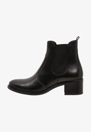 Stivale in pelle nera alla caviglia con punta arrotondata, pannelli laterali elastici e tacco a blocco. Texture liscia con dettagli di cucitura minimi.