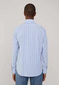 Blau-weiß gestreiftes Hemd mit langen Ärmeln, das einen Button-Down-Kragen und einen abgerundeten Saum hat. Der Stoff wirkt glatt mit einem subtilen Glanz.
