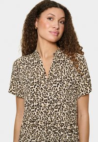 Robe à manches courtes imprimée léopard avec décolleté en V et jupe froncée, fabriquée dans un tissu léger à la texture lisse.