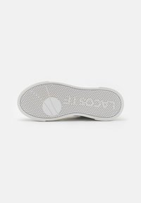 Biała podeszwa do sneakersów z heksagonalnym wzorem, z okrągłym logo i dwiema poziomymi liniami. Gładka tekstura i zaokrąglone krawędzie.