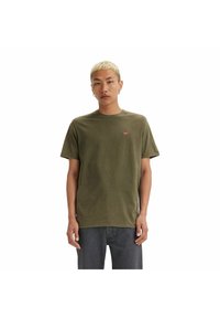 Camiseta de algodón verde oliva con cuello redondo, mangas cortas y un pequeño logo rojo de Levi's en el pecho izquierdo. Diseño simple y casual.