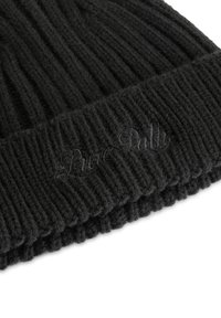 Zwarte gebreide beanie met een ribbelstructuur en omgeslagen rand, met subtiele borduurwerk van "Pure" in zwarte draad op de rand.