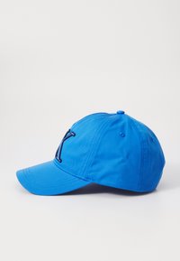 Blauwe pet van stof. Voorzien van geborduurd zwart "Y" logo op de voorkant, gebogen klep en verstelbare achterkant.