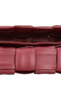 Borsa in pelle rossa con design strutturato. Presenta sezioni trapuntate e una texture liscia. Forma compatta con dettaglio di chiusura integrato.