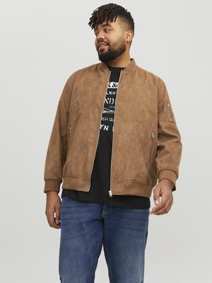 Chaqueta bomber de ante marrón con puños y dobladillo acanalados, que presenta un cierre de cremallera en la parte delantera, bolsillos laterales y un bolsillo con cremallera en el brazo izquierdo.
