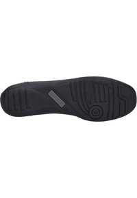 Suela de zapato de goma negra con patrón de agarre texturizado, que presenta un detalle circular y un logotipo en relieve. Forma plana diseñada para estabilidad y tracción.