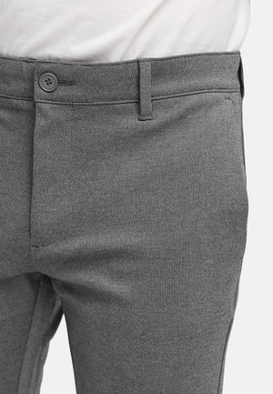 Pantalones grises ajustados con una tela texturizada, que cuentan con un cierre de botón en la cintura, bolsillos laterales y un ajuste elegante y moderno.