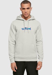 Light gray hoodie with a kangaroo pocket, drawstring hood, and multicolored graphic design in the center. Soft fabric texture evident.
