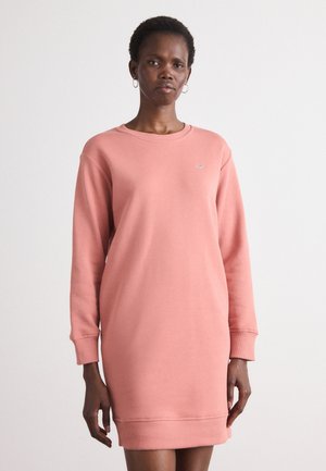 Rosa sweatshirtklänning med långa ärmar, rundad halsringning och ribbade mudd. Har en liten logotyp på bröstet. Slät textur.