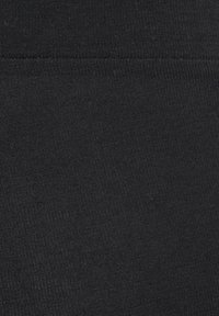 Svart ribbat tyg med en strukturerad yta och horisontell stickning, som visar en sömlös design och enhetlig färg genom hela tyget.