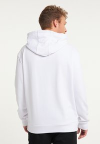 Hvid hættetrøje med lange ærmer, snoretræk i hætten og ribbede manchetter. Let løstsiddende pasform, glat tekstur, minimalistisk design.